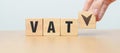 hand change wooden block with VAT text to UP and Down arrow icon. Value Added Tax, decrease and Increase, Taxpayer, Taxable Income Royalty Free Stock Photo