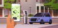 hand charging electric car in mobile app battery vehicle at recharging power station charger EV management zero emission