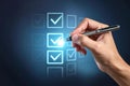 Hand checking digital checklist with pen in futuristic interface Royalty Free Stock Photo