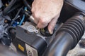 Hand checking the oil cap of a car engine Royalty Free Stock Photo