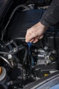 Hand checking the oil level of a car engine