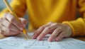 Hand checks box on paper document using yellow pencil. Person completes task, fills form, passes test, answers questionnaire,