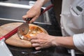 Hand of chef cutting pizza Royalty Free Stock Photo