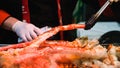 Hand of Chef holding and grilling big king crab legs at seafood market at japan Royalty Free Stock Photo