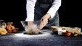 Hand of chef man wear grey apron knead dough in the glass bowl with egg on table. Ingredients for cooking products or bread, Royalty Free Stock Photo