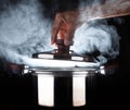 Hand of chef open hot stream pot with beautiful studio lighting