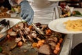 Chef on put plate of sliced hot roast leg of lamb and lamb ribs cooked on grill Royalty Free Stock Photo