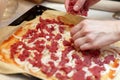 Hand chef puts on pizza meat