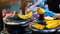 Hand of chef using burner burn sliced of Japanese sweet cantaloupes and other fruits on stove to sale at Kuromon market. Cantaloup Royalty Free Stock Photo