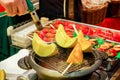 Hand of chef using burner cooking and burn slice of cantaloupes and melons on stove to sale for customer at Kuromon market.