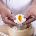 Hand of chefd holding steamed dumpling bun