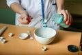 The hand of the chemist puts the powder into a bowl Royalty Free Stock Photo