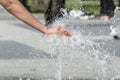 A hand of child bathes in a fountain in a city park. International Children`s Day