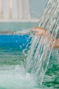 Hand of child creates splashes in the water flow