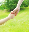 Hand child and hand mother closeup over summer