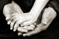 The hand of a child in the hands of a grandmother. elderly woman`s hands and baby`s hand. black and white. Royalty Free Stock Photo