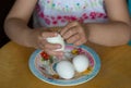 Hand of child peeling egg pulling off shell