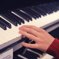The hand of a child pianist choosing a synthesizer in a musical instrument store. Electronic piano keys, close-up Royalty Free Stock Photo