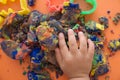 Hand of child playing multicolored kinetic sand. children activity game toy for model forming craft and sculpture art Royalty Free Stock Photo