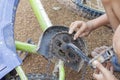 Hand of children practice repairing a chain link of a bicycle by themselves.