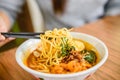 Hand with Chinese chopsticks eating noodle