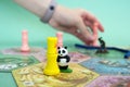 hand with chip under the playing field. game cards and chips on table close up. Takenoko Board game and leisure concept