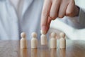 Hand Choose figure standing out from the group of crowd. Business hiring and recruitment selection.