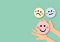 Hand choose holding pink happy face circle with colour circles, positive thinking.