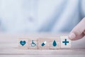 Hand chooses a emoticon icons healthcare medical symbol on wooden block , Healthcare and medical Insurance concept Royalty Free Stock Photo