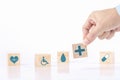 Hand chooses a emoticon icons healthcare medical symbol on wooden block , Healthcare and medical Insurance concept Royalty Free Stock Photo