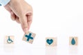 Hand chooses a emoticon icons healthcare medical symbol on wooden block   Healthcare and medical Insurance concept Royalty Free Stock Photo