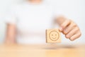 Hand choosing happy face from Emotion block for customer review, good experience, positive feedback, satisfaction, survey, Royalty Free Stock Photo