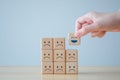 Hand choosing the happy face among unhappy faces on wooden blocks. Positive thinking. Royalty Free Stock Photo