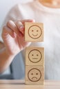 Hand choosing smile face from Emotion block for customer review, good experience, positive feedback, satisfaction, survey, Royalty Free Stock Photo