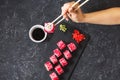 Hand with chopsticks on sushi set with soy sauce on black stone desk. Royalty Free Stock Photo