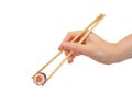 Hand with chopsticks taking maki roll, Japan sushi with salmon, isolated on white Royalty Free Stock Photo