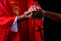 Hand of christian pastor giving love and cross