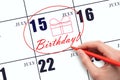 The hand circles the date on the calendar 15July, draws a gift box and writes the text Birthday. Holiday. Royalty Free Stock Photo