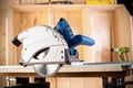 Hand circular saw with piece of wood on workbench. closeup sawing machine woodworking construction tool concept furniture making