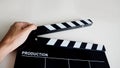Hand with clapper board or movie slate use in film or video production and cinema industry. It`s black color on white background Royalty Free Stock Photo