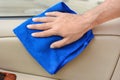 Hand cleaning interior car door panel with microfiber cloth Royalty Free Stock Photo