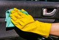 Hand cleaning interior car door panel with the microfiber cloth . Worker at the car wash. Royalty Free Stock Photo