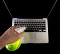 Hand cleaning a laptop with a spray bottle sanitizer Royalty Free Stock Photo