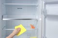 Hand cleaning refrigerator. fridge cleaning - spray bottle with detergents for washing the fridge Royalty Free Stock Photo