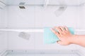 Hand cleaning refrigerator with rag Royalty Free Stock Photo