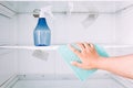 Hand cleaning refrigerator with spray bottle Royalty Free Stock Photo