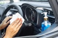 New normal lifestyle concept with woman hand cleaning on steering wheel during covid-19 with alcohol  gel in car Royalty Free Stock Photo