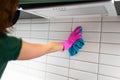 Hand of the cleaning woman wipes tiles in the kitchen. Royalty Free Stock Photo