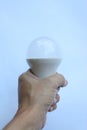 Hand clutching the white light bulb Royalty Free Stock Photo