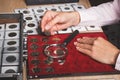 Hand with coin, box with collectible coins in the cells and a page with coins in the pockets